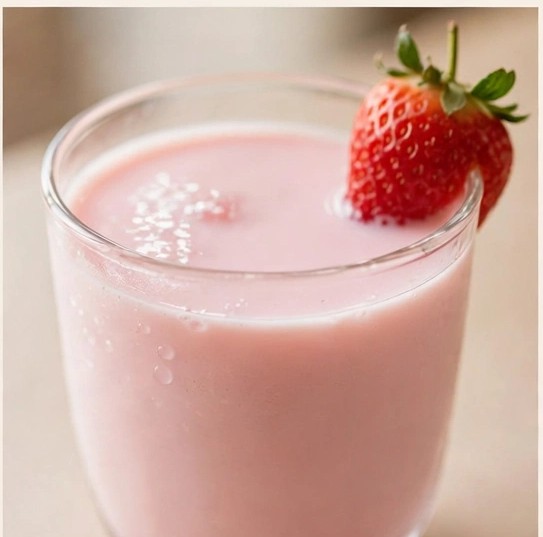 A pink strawberry mix drink garnished with a fresh strawberry